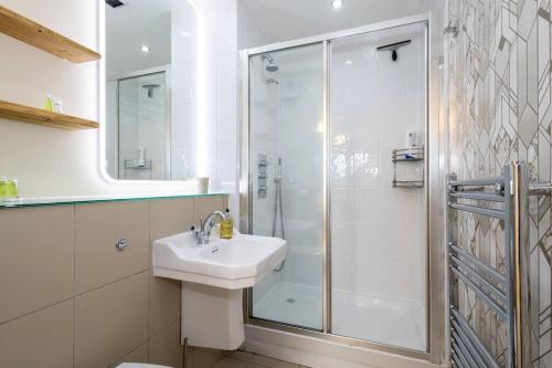 曼彻斯特The Didsbury的带淋浴和盥洗盆的白色浴室
