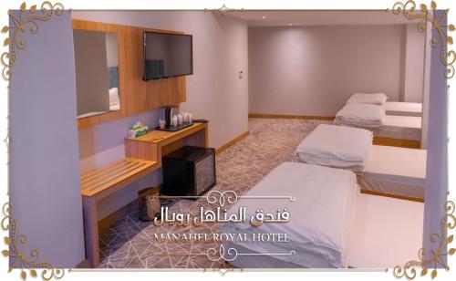 纳杰夫Al-Manahel Royal Hotel的客房设有两张床和一台平面电视。