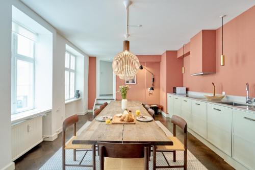 哥本哈根Stylish Spacious Flat w 3BR in Copenhagen City的一个带木桌和椅子的大厨房