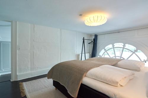 哥本哈根Stylish Spacious Flat w 3BR in Copenhagen City的一间卧室配有一张位于上面的光线的床