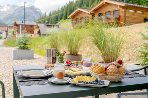 莱赫阿尔贝格Apart-Hotel Laurus Lech的一张带食物、面包和牛奶的野餐桌