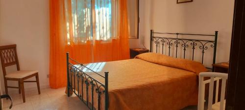 切萨雷奥港Villa Bouganville的一间卧室配有一张带橙色毯子和椅子的床