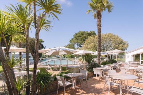 诺亚芒提亚芙蓉塞尔酒店的一个带桌椅的庭院,棕榈树