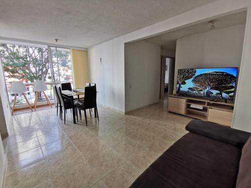 布卡拉曼加Mi hogar - Apartamento familiar en Bucaramanga的客厅配有电视和桌椅