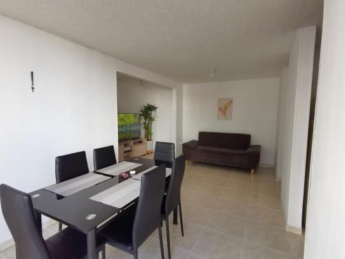 布卡拉曼加Mi hogar - Apartamento familiar en Bucaramanga的一间带桌椅和沙发的用餐室