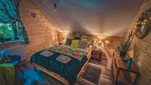 什切尔克Chata na Skarpie - SPA i widok na Skrzyczne的木制客房内的一间卧室,配有一张床