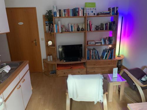 奥斯特拉赫Einladendes Appartement im Grünen für 2 Personen的客厅配有电视和桌椅