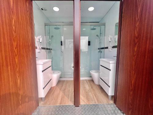 埃尔帕尔马Caravana Con Encanto El Palmar 4的一间带两个卫生间和玻璃淋浴间的浴室