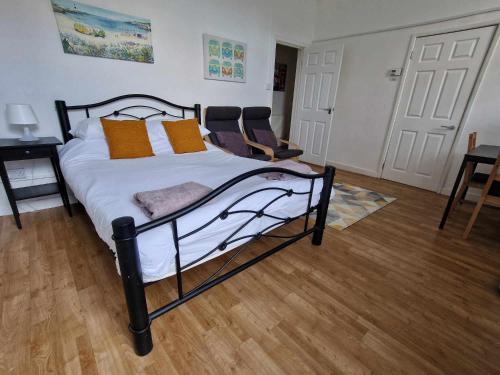 埃克塞特Studio Apartment, Private Parking, Walk To Centre, Uni and Hospital, Long Stay Prices的一间卧室配有黑色和白色的床以及橙色枕头。