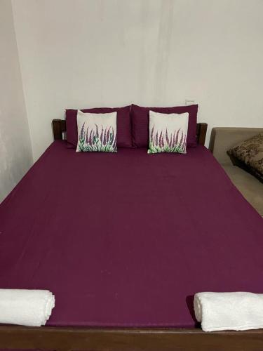 KandakuliThe Crab Beach Resort的紫色床、紫色床单和枕头