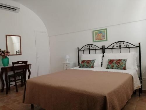 桑布卡迪西奇利亚Le Stanze dell'Emiro的一间卧室配有一张床和一张桌子及椅子