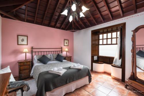 马佐Lightbooking La Morera Villa de Mazo con piscina的一间卧室设有一张床和木制天花板