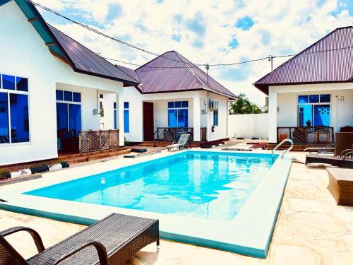 帕杰Mbuyu Uvi Apartment的房屋前的游泳池