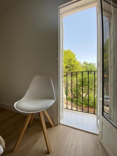 莫哈卡尔Apartamento PLAYA LAS VENTANICAS的窗前的白色椅子