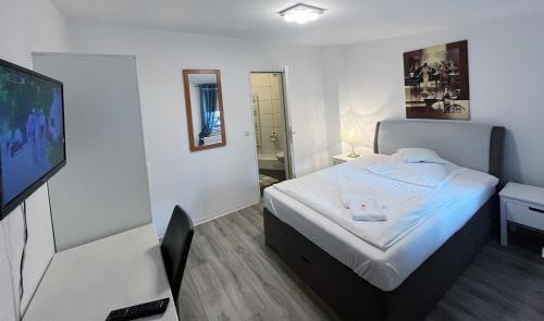 汉诺威Restaurant Donau的配有一张床和一台平面电视的酒店客房
