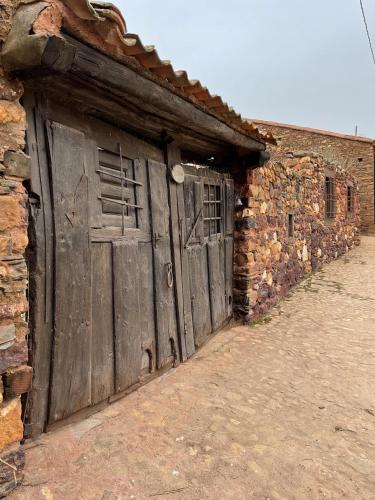 马德古拉Stunning 7-Bed House in Madriguera的砖砌建筑中带木门的旧谷仓
