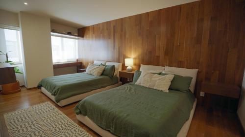 墨西哥城3 Bedroom Apartment in Polanco - best location的木镶板客房内的两张床