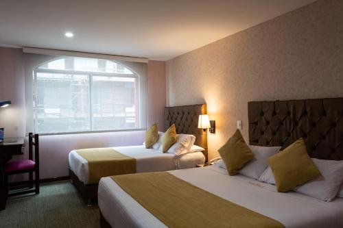 波哥大Hotel Risot的酒店客房设有两张床和窗户。