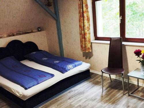 比克克森特凯赖斯特Traumhaftes Ferienhaus im Buchengebirge的一间卧室配有一张床、一把椅子和一张桌子