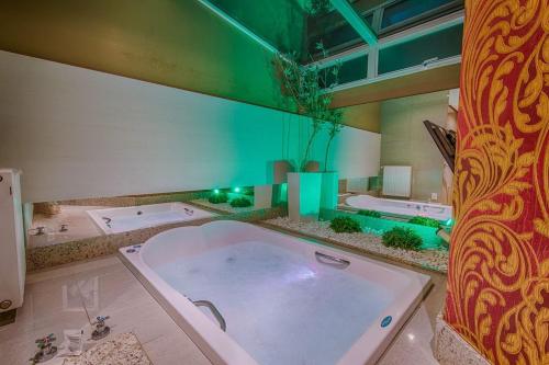 南卡希亚斯Ettus的大型浴室设有大浴缸和两个爵士乐
