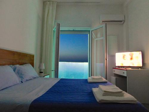 罗迪-加尔加尼科Albergo Lido Diomedee的一间卧室配有一张带蓝色毯子的床和窗户。