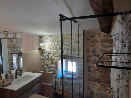 拉戈尔斯LA TERRASSE AUX HIRONDELLES avec SPA maison 80m2 2 chambres 2 salles de bains的一间带水槽和玻璃淋浴的浴室