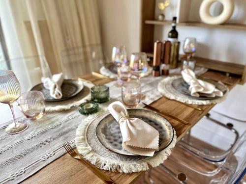 舍讷费尔德BALI HOME Stylische Wohnung mit Terrasse的木桌,带盘子和餐巾及酒杯