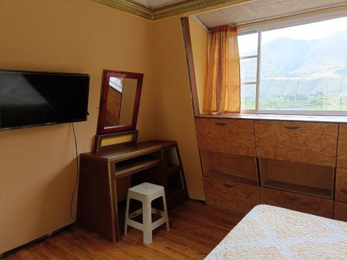 伊瓦拉BUNGALOWS YAHUARCOCHA的一间卧室配有电视、镜子和凳子