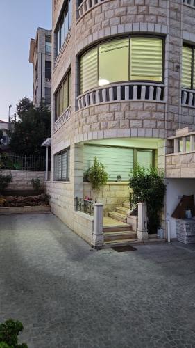 拿撒勒Maria's GuestHouse - Uphill View of Nazareth F的一座带绿门和楼梯的大型砖砌建筑