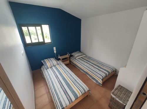 拉特斯特德布赫2 Maisons de 3 et 2 chambres avec grande piscine commune的蓝色墙壁客房的两张床