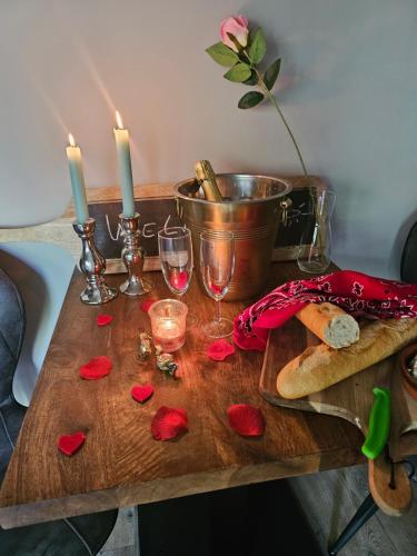 埃曼Jacuzzi huisje De Berenshoeve的一张桌子,上面放着两根蜡烛和酒杯