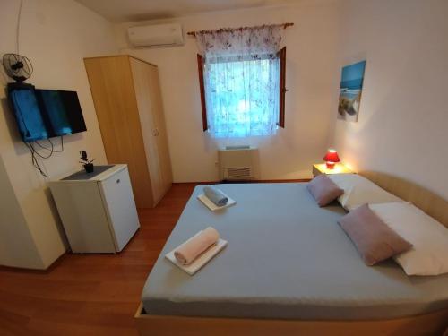 卡尔卢巴格Soba Ivanka Nikšić的一间卧室配有一张大床和两条毛巾