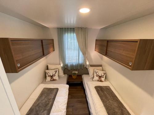 聚滕达尔Chalet Het Edelhert的小房间设有两张床和窗户