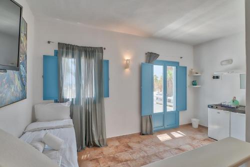 安迪帕罗斯岛Palm Heaven Boutique Apartments的一间拥有蓝色和白色墙壁的卧室和一间厨房
