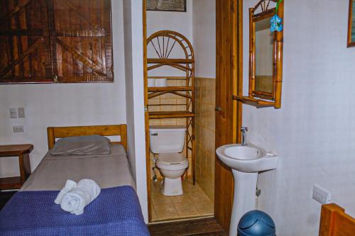 多米尼克Casa Sua--Cozy 3 Bedroom Dominical Beach Cottage with Pool的浴室设有床、卫生间和水槽。