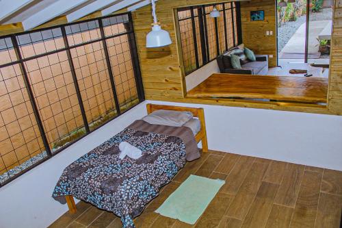 多米尼克Casa Sua--Cozy 3 Bedroom Dominical Beach Cottage with Pool的一间房间中间设有一张床