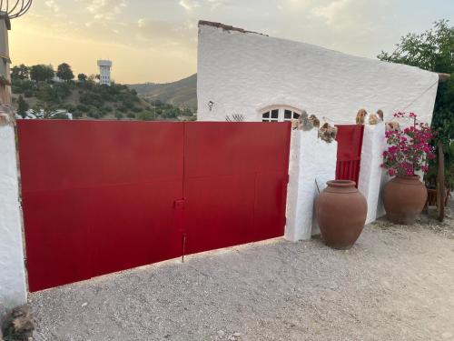 SalirMonte Carrascal Guesthouse的白色建筑前的红色门