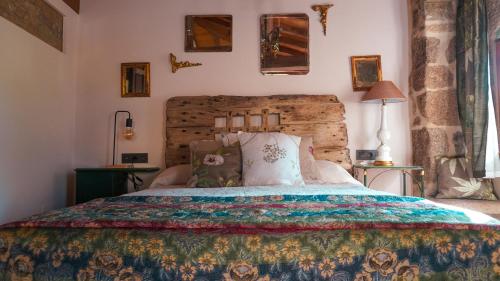 诺盖拉德拉姆Casa la Trinidad - Ribeira Sacra的一间卧室配有一张带彩色床罩的床