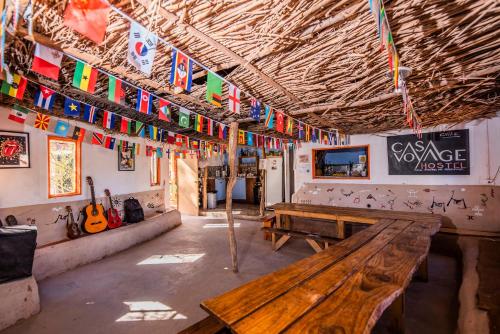 圣佩德罗·德·阿塔卡马Casa Voyage Hostel的天花板上悬挂着长椅和旗帜的房间