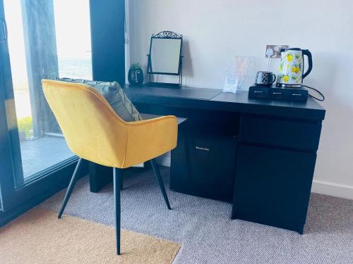 柯科迪Luxury beach front rooms- PMA的一张桌子和一张黄色椅子