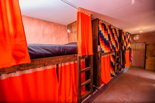 圣佩德罗·德·阿塔卡马Casa Voyage Hostel的窗帘间的一排床