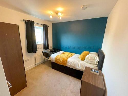 赫尔4 bed house, fully equipped & close to amenities.的一间卧室设有一张床和蓝色的墙壁