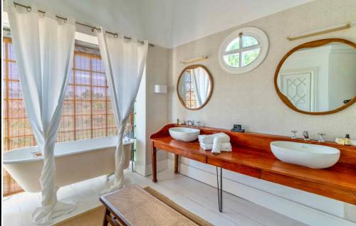 马贝拉The Pearl - Marbella的浴室设有2个水槽、浴缸和镜子