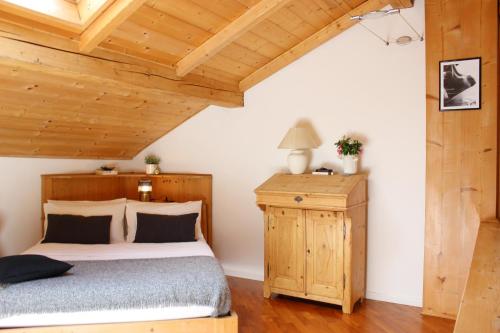 Tenna Serenity Escapes - Caldonazzo Lake的一间卧室设有一张床和木制天花板