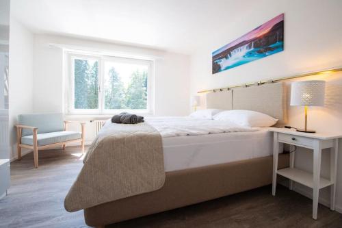 韦齐孔Moderne & helle Wohnung mit Netflix & Bergsicht的白色卧室配有一张大床和一张书桌