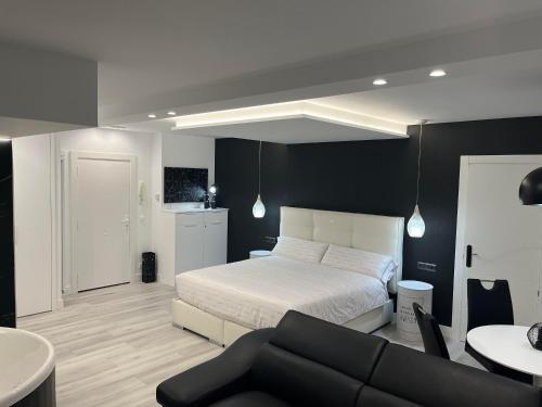 乌迪亚莱斯堡Black and White Suite Castro Urdiales的卧室配有白色的床和沙发
