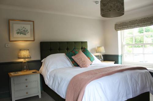 Saint Mary BourneThe George Inn St Mary Bourne的一间卧室设有一张大床和一个窗户。