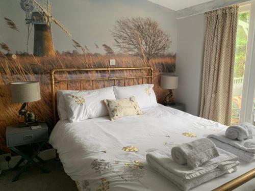 霍尔沃盖特Peaceful Norfolk Broads 1 Bedroom 2 bath annexe的一间卧室配有带毛巾的床