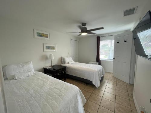 西棕榈滩Guest houses West Palm Beach 2BR or 1BR的一间卧室配有两张床和吊扇