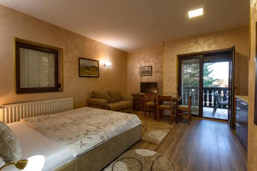 兹拉蒂博尔Apartment Vila Simovic的一间卧室配有一张床和一张桌子及椅子